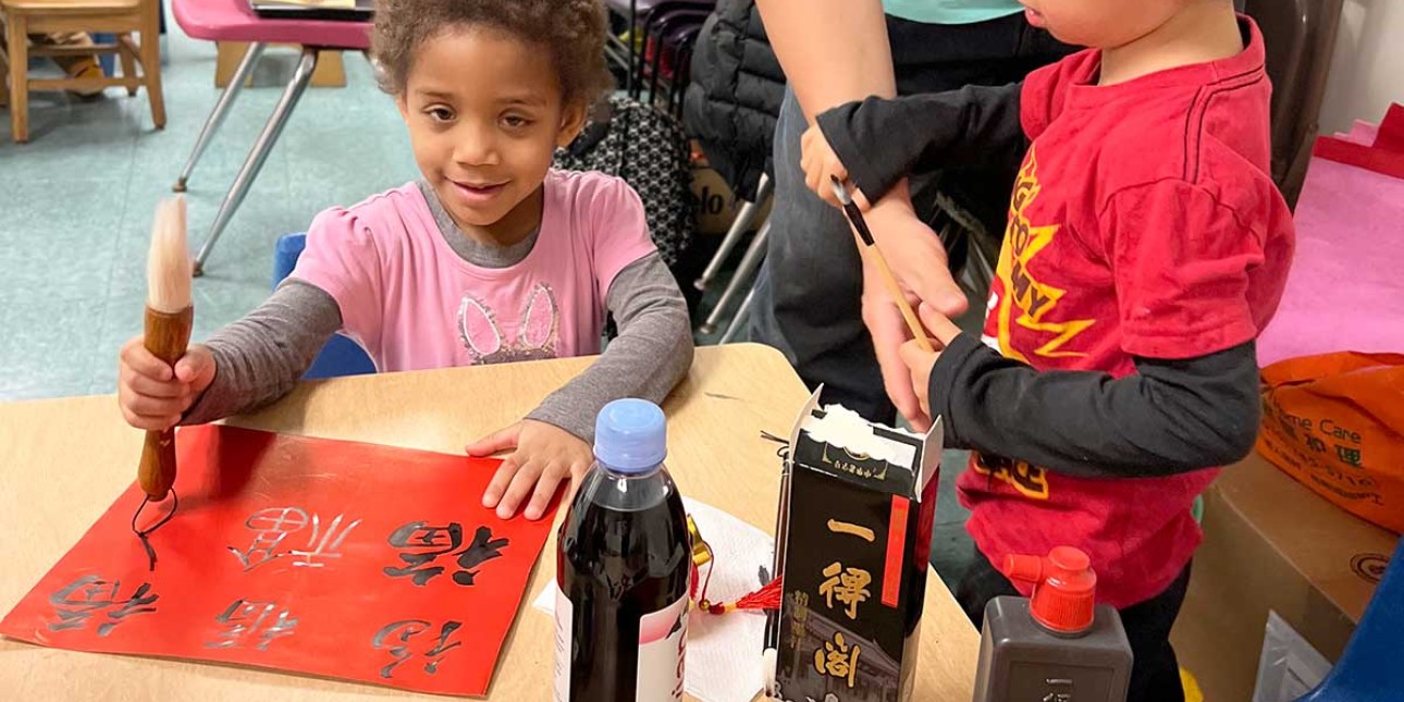 Preschooler learning calligraphy at Lunar New Year celebration