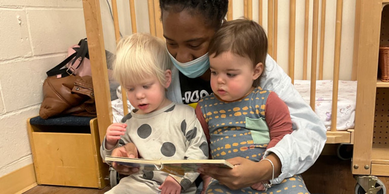 teacher reading to two young toddlers