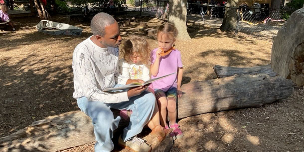 Teacher reading on nature playground
