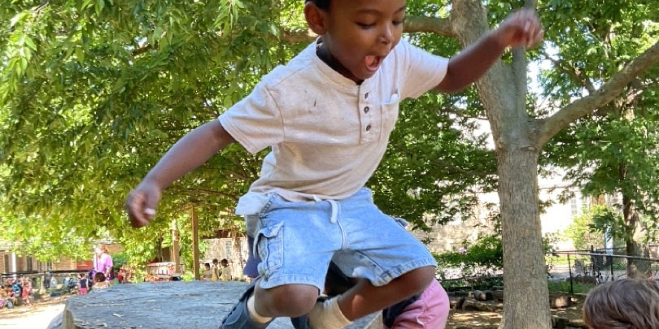 preschooler jumping off a stump